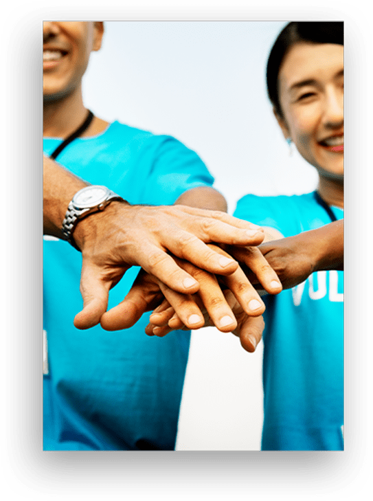 people stacking their hands on top of one another in comradery